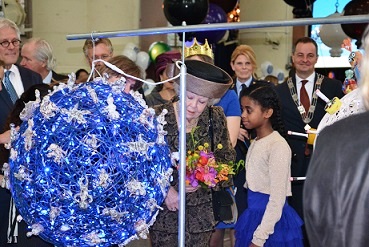 Scholiere Heaven bij haar kunstwerk en naast de net afgetreden Koningin